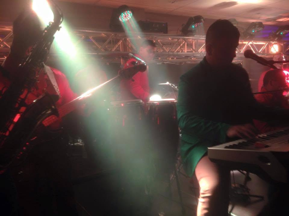 The AMW band mid-set under stage lighting